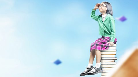 Girl sitting on books looking to the sky