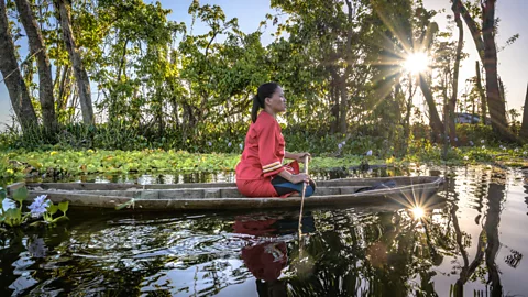 Gab Mejia A woman steers her traditional boat through a lake in the Philippines (Credit: Gab Mejia)