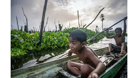 Gab Mejia Manobo children play in their parents' traditional canoes after attending lessons in their floating school (Credit: Gab Mejia)