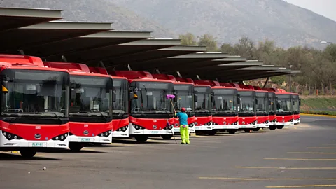 Getty Images A row of red electric buses line up in a depot