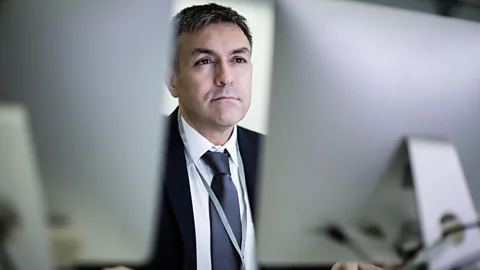 Alamy Man sitting in front of two monitors