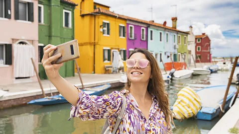 sco Vaninetti Photo/Getty Images Woman taking a selfie in Burano, Venice