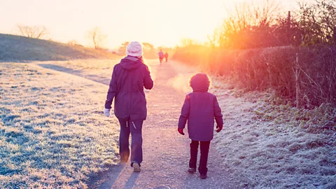 Getty Images Two people out for a winter walk with frost on the ground (Credit: Getty Images)