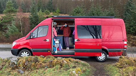 Holly standing in her van with a cup of tea