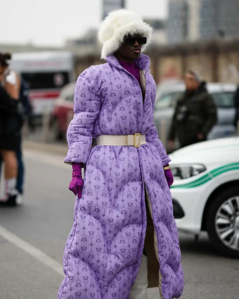 Getty Images Fashion is having a cosy moment – such as this long duvet-style coat and faux-fur hat, as worn by a guest at Milan autumn/winter 2023-24 fashion week (Credit: Getty Images)