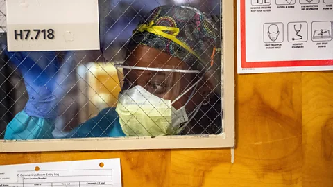 Getty Images A hospital worker looks through a window into a ward (Credit: Getty Images)