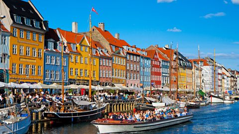 A row of houses painted in different colours lining the harbour of Copenhagen.