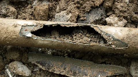 Getty Images A broken asbestos cement pipe in the ground (Credit: Getty Images)