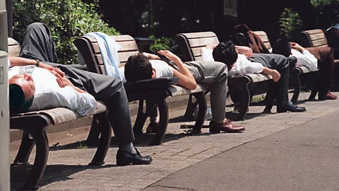Getty Images Japanese workers napping on park benches (Credit: Getty Images)