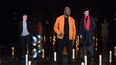 Three actors standing on stage during a performance of William Shakespeare's 'The Merchant of Venice'.