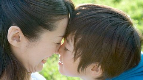 A mother and child smiling and rubbing noses together