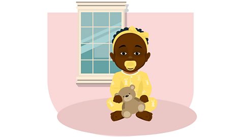 A Black baby wearing a yellow headband, sucking dummy and holding a teddy bear.