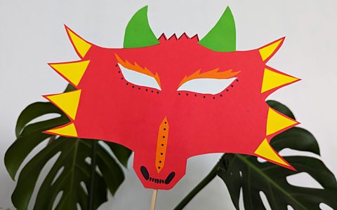 A red, yellow, orange and green paper mask of a dragon for Lunar New Year.