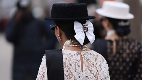 A picture of a woman with a bow in her hair at Paris Fashion Week