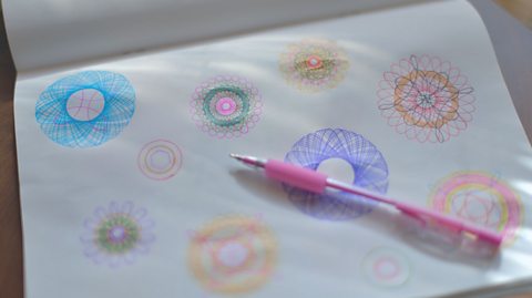 A piece of paper with colourful geometric doodles with loop shapes.