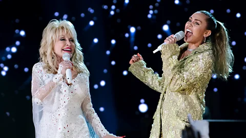 Getty Images Miley Cyrus' father, Billy Ray Cyrus, asked Dolly Parton to be Miley's godmother after they toured together in the early 1990s (Credit: Getty)