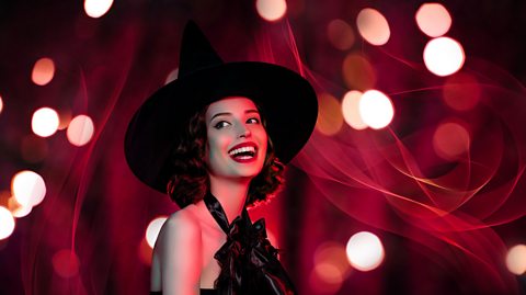 A young woman dressed as a witch, wearing a witch's hat and red lipstick.