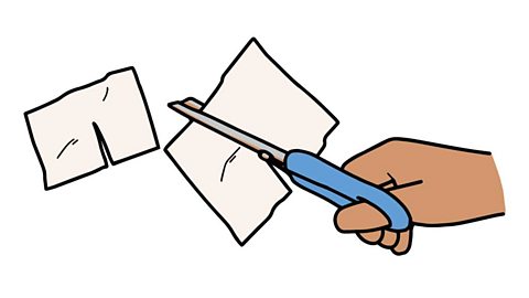 A hand cutting a slot into a piece of paper with a pair of scissors