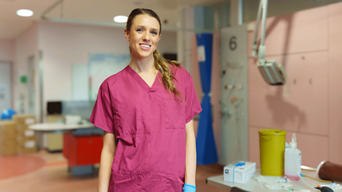 Charlie Tee in scrubs in a hospital.