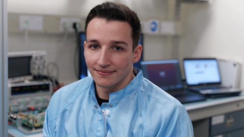 Software engineer, Jaydan, at work, smiling to camera.