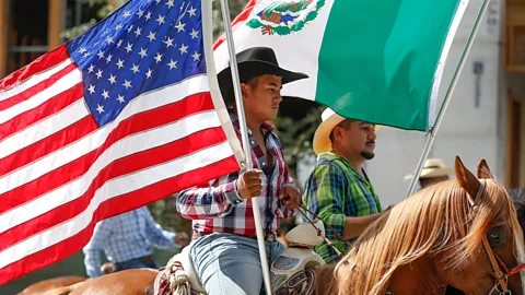 Getty Images Horse riders carry American and Mexican flags during the Annual Houston Fiestas Patrias Parade in Houston (Credit: Getty Images)