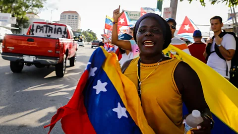 Getty Images A woman holds a Venezuelan flag in Miami (Credit: Getty Images)