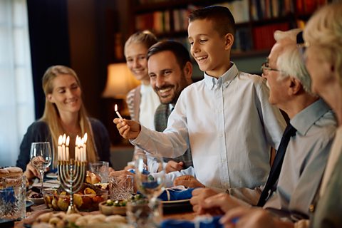 A Jewish boy lighting the Menorah