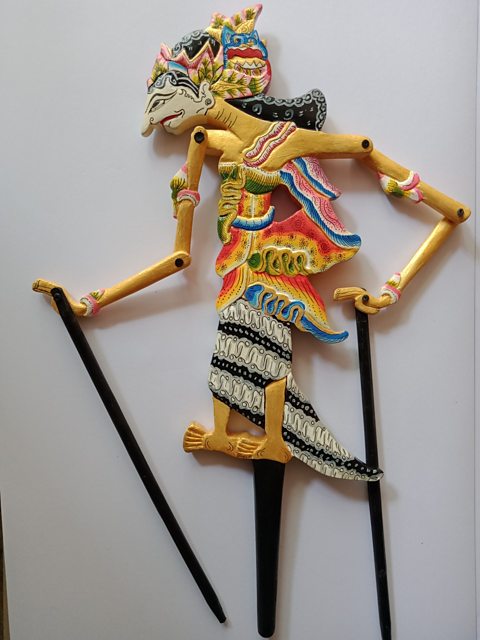 A photo of a colourful and highly decorated wooden puppet of a woman with long black hair, operated with wooden rods