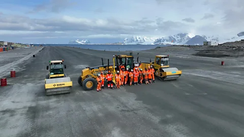 BAM Workers stand in front of earth moving machinery on a runway at Rothera Research Station in Antarctica (Credit: BAM)