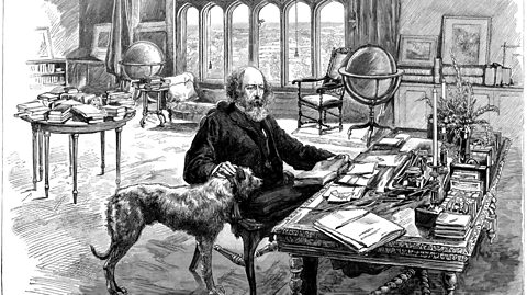 A black and white drawing of a man with a long beard sitting at a desk covered in notebooks, stroking a dog.