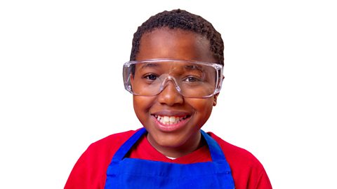 Child wearing a blue apron and safety goggles