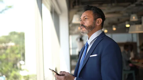 Getty Images Gen X worker holding mobile phone (Credit: Getty Images)