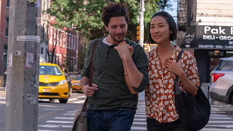 A24 Nora describes inyeon to her husband-to-be, Arthur (John Magaro), as "something Koreans say to seduce someone" (Credit: A24)