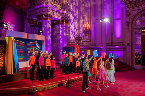 The Capital Choir sing in the background, as Skylar leads a group of dancers.