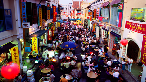 Large groups of people eating in a hawker market 