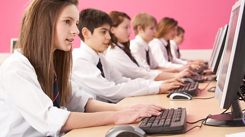 School students working in computer lab with pink background wallpaper