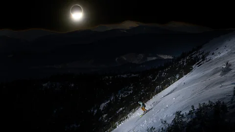 Andy Gagne Photography Person skiing under the eclipse at Saddleback Mountain, Maine