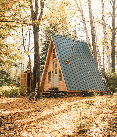 Andrew Szeto Made using reclaimed doors and windows, the small footprint of this A-frame in the woods of Quebec encourages outdoor living (Credit: Andrew Szeto)