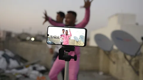 Getty Images A mobile phone on a stand films two Indian men as they make a video (Credit: Getty Images)