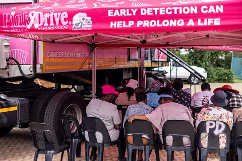 Getty Images Women waiting outside a cancer screening van (Credit: Getty Images)