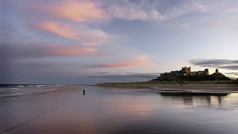 Getty Images Bamburgh Castle sits on a high basalt crag overlooking the North Sea (Credit: Getty Images)
