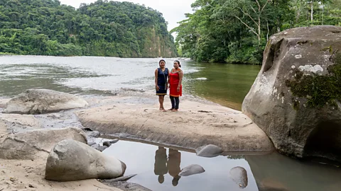 Ana Maria Buitron Leila Cerda and Elsa Cerda, leaders of the Serena community, stand by the Jatunyacu River, which is at the heart of their community (Credit: Ana Maria Buitron)