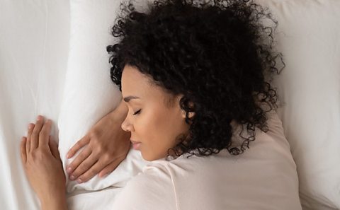 A woman lying asleep in bed