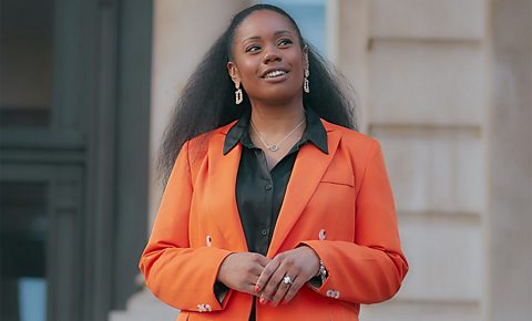 Life coach Aisha Gordon-Hiles in an orange blazer and black shirt