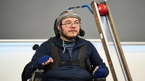 Boccia champion Rafael Young playing boccia with a special pusher and ramp.