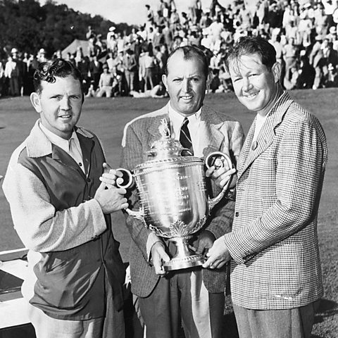 Byron Nelson is presented with the PGA Tour trophy at the Moraine Country Club in Ohio. This image shows Byron on the right with the runner-up, Sam Byrd, smiling as he presents the trophy to his competitor