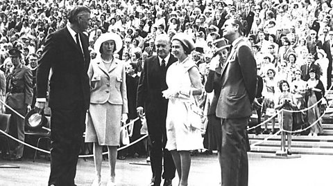 Queen Elizabeth II and the Duke of Edinburgh with dignitaries Sir Roden and Lady Cutler, and Sir Robert and Lady Askin at the official opening of Sydney Opera House with a large crowd of spectators behind them