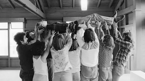 Getty Images A group of peoplle at the Berkeley Holistic Health Center in Berkeley, California in the 1970s engaged in a Healing Circle, in which the group lift up one person, transmitting positive energy