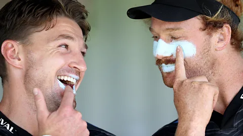 Getty Images Two rugby players applying suncream during a training session in New Zealand (Credit: Getty Images)