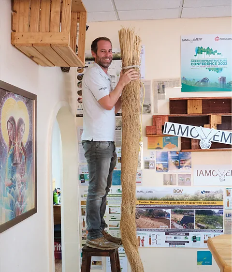 Damir Ali Jonathan Barcant, founder of the IAMMovement nonprofit, poses with dried vetiver root in his office in Trinidad (Credit: Damir Ali)